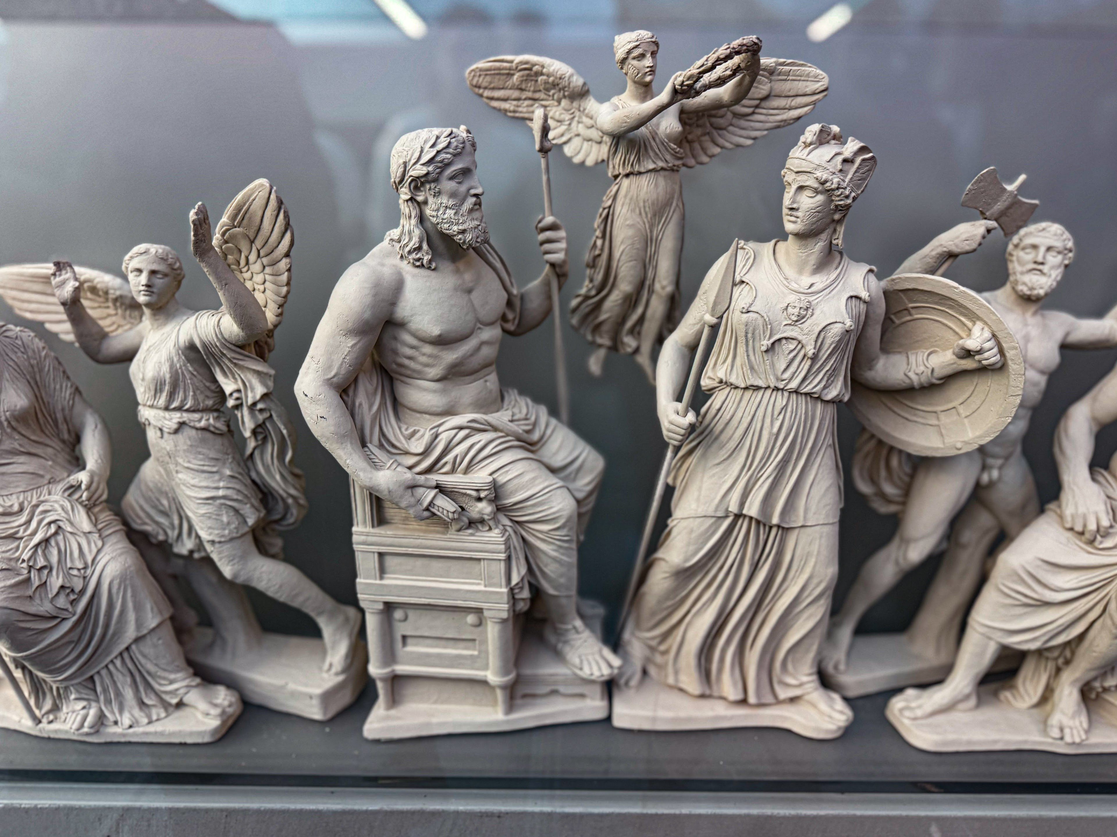 Starożytna rzeźba grecka przedstawiająca Atenę i innych bogów związanych z mitem o powstaniu Aten.