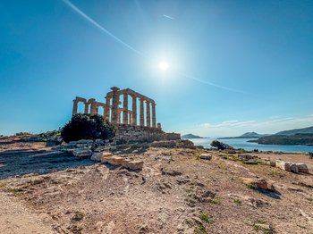 Ruiny starożytnej Świątyni Posejdona na przylądku Sounion, z widokiem na Morze Egejskie i błękitne niebo, idealne miejsce na zachód słońca. Płatności kartą i gotówką są akceptowane przy zakupie biletów.