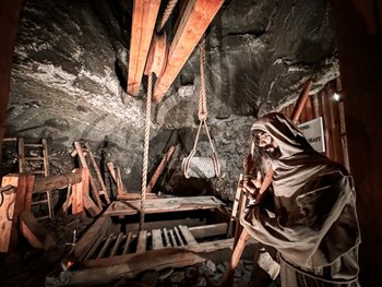 Interior of the Wieliczka Salt Mine featuring wooden structures, ropes, and a reenactment of historical salt mining methods.