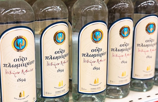 Bottles of Ouzo Plomari, a popular Greek anise-flavored spirit, displayed in a row.