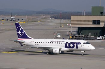 LOT Polish Airlines aircraft on the tarmac at Warsaw Chopin Airport (WAW), representing air travel to Poland's capital.